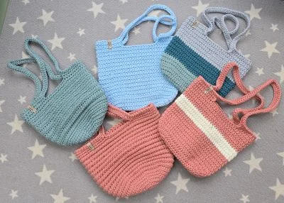 Kollektion von bunten, handgearbeiteten Handtaschen aus Textilgarn